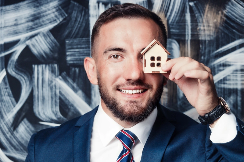 real estate agent holds toy house